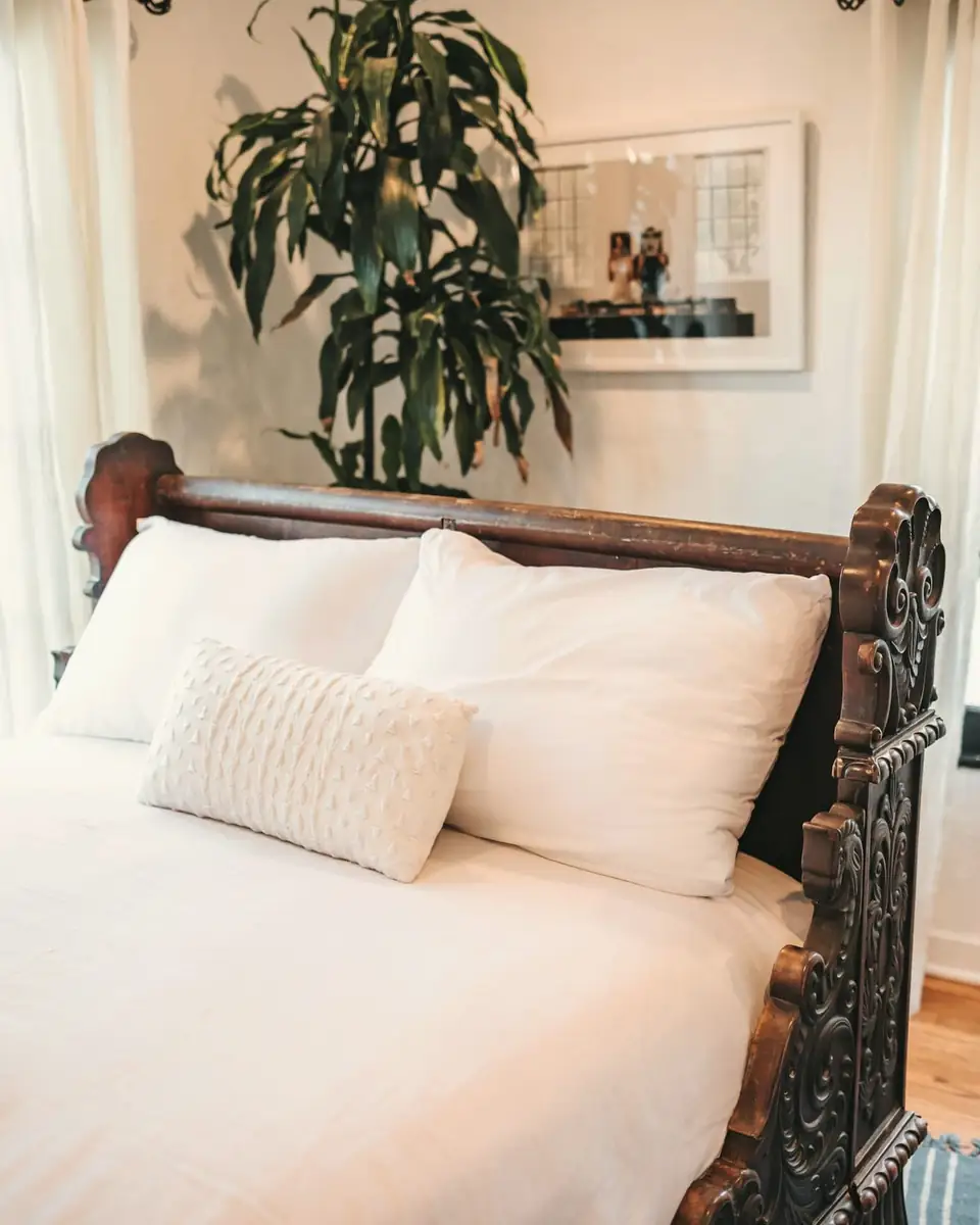 White pillows and linen against a carved timber headboard