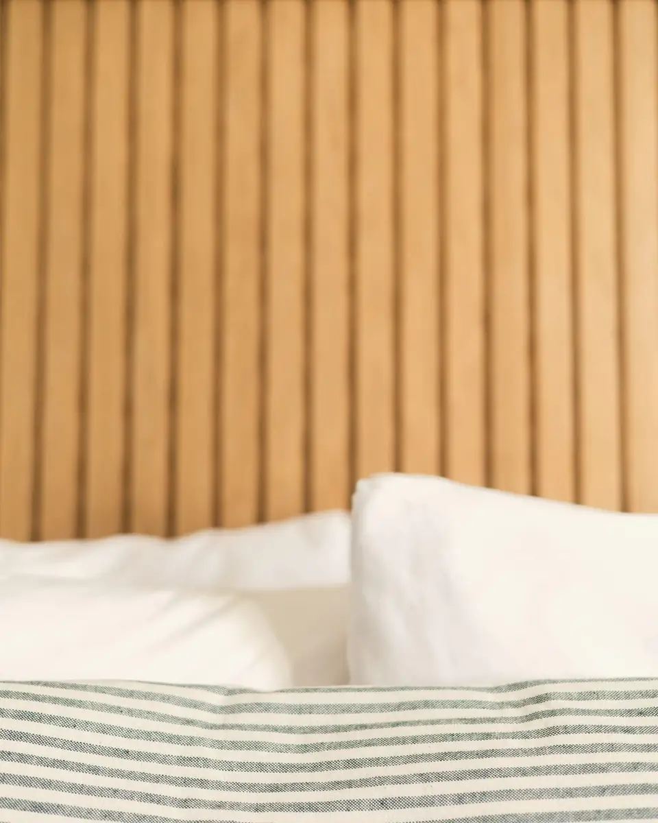 Linen bedding against a timber slatted headboard