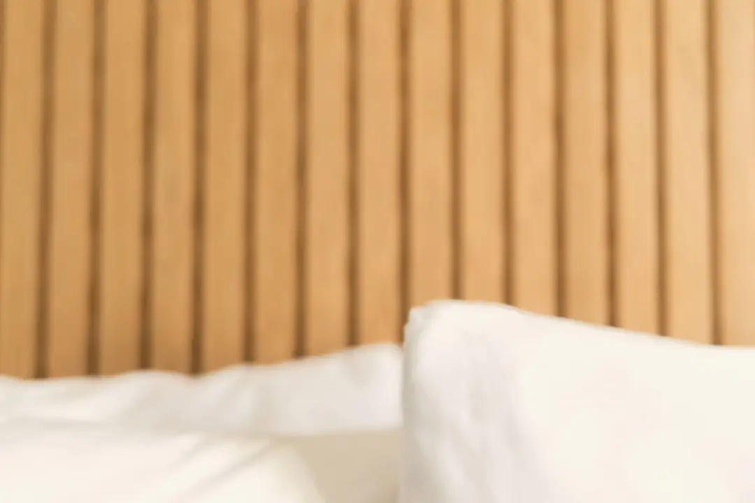 Linen bedding against a timber slatted headboard