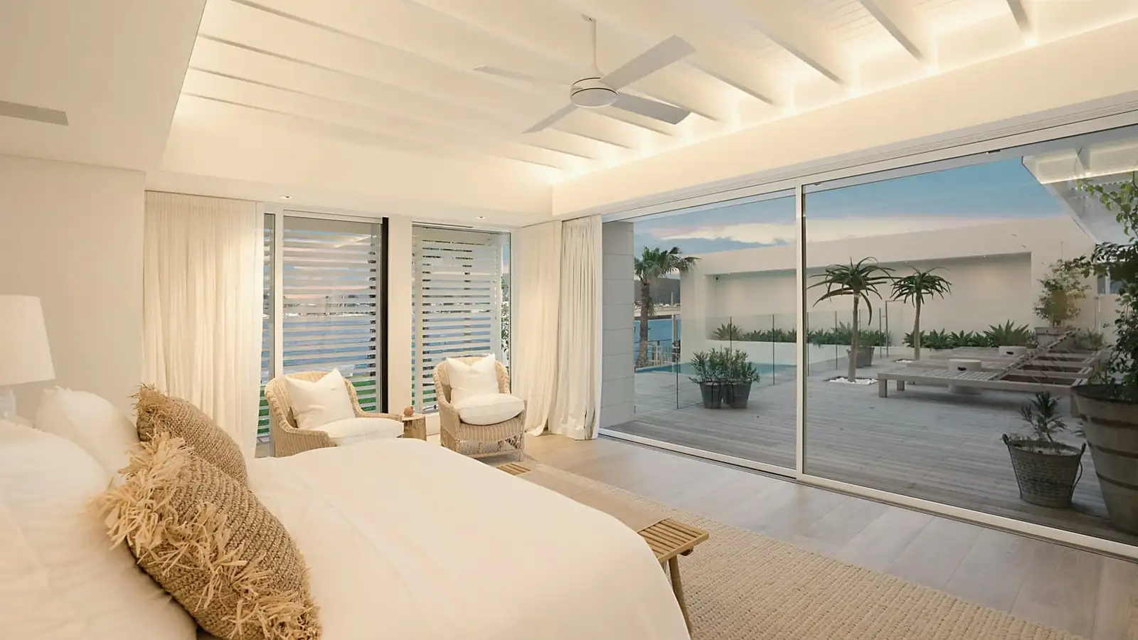 Bright bedroom with tall glass doors opening onto a terrace