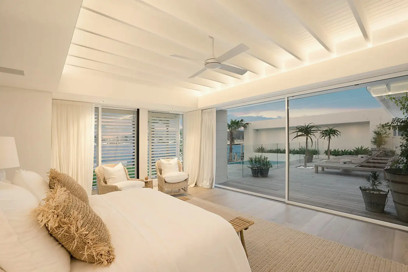 Bright bedroom with tall glass doors opening onto a terrace