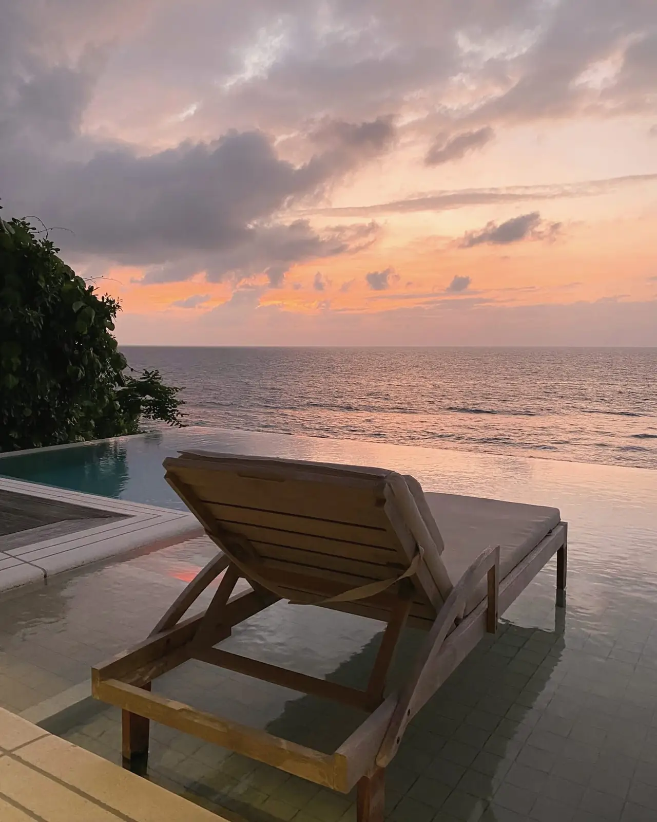 Timber lounger facing the sea at dusk