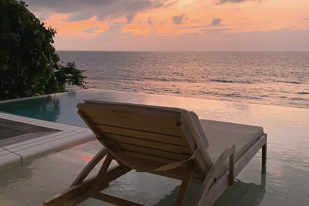Timber lounger facing the sea at dusk
