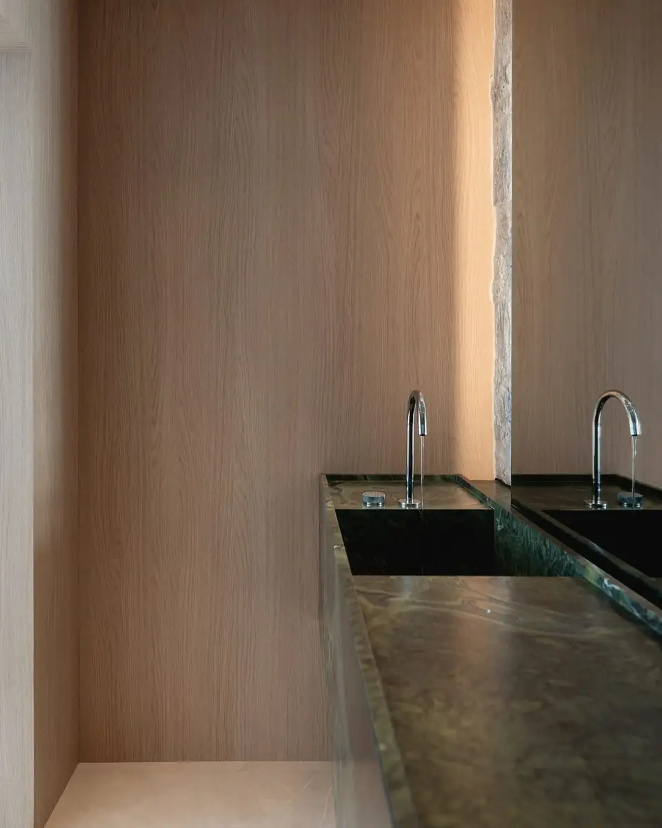 Stone counter with two basins in a timber-lined bathroom