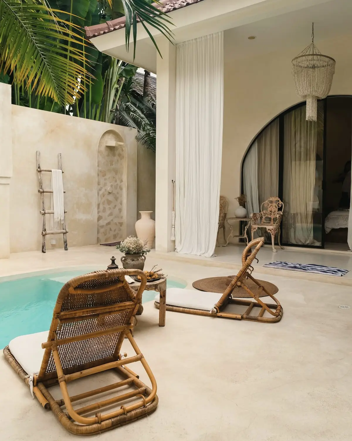Limestone terrace with two rattan loungers beside a small plunge pool
